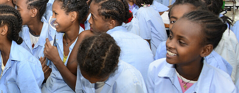 Äthiopische Straßenkinder am Lernen: Sie wirken erfreut über die Chance Bildung zu erfahren. Weiters sind sie alle einheitlich in blauen Hemden und schwarzen Röcken gekleidet. 