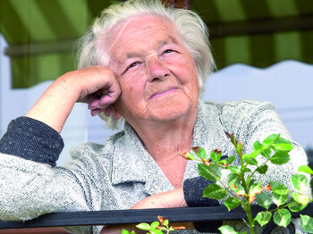 Senior woman leaning on hand and looking forward.