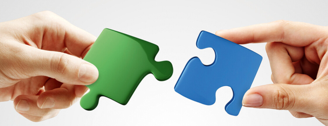 Hands and puzzle on gray background. Teamwork solving a puzzle