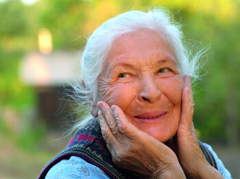 Portrait of the laughing elderly woman. A photo on outdoors
