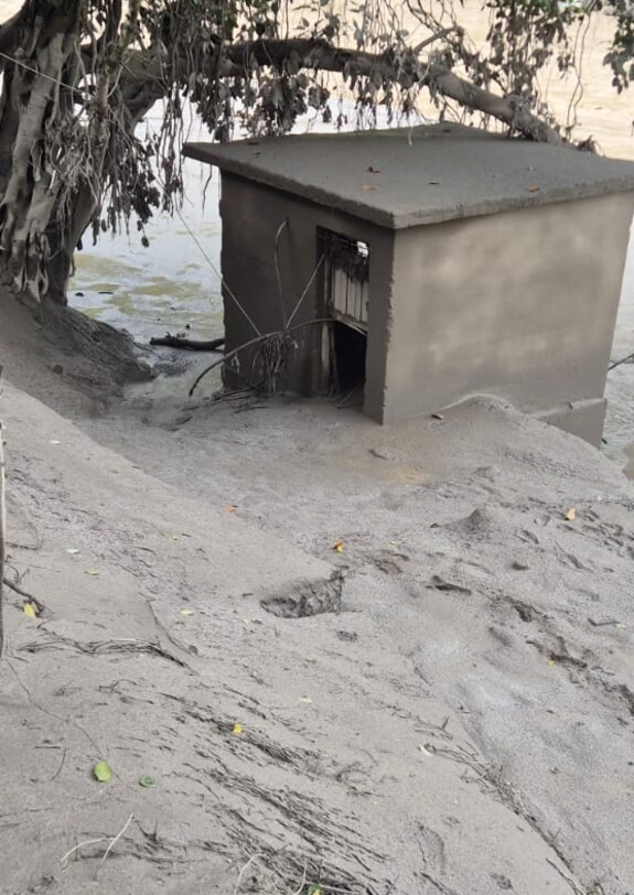 Schlamm und Geröll haben ein kleines Gebäude und den Boden unter einem großen Baum nach der Flut in Nepal verschüttet.