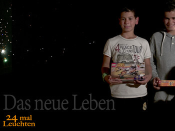 Zwei junge Buben erleuchtet auf schwarzem Hintergrund. Die Kinder strahlen und halten ein Geschenk in der Hand.