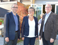 Walter Schmolly, Peter Klinger und eine Frau befinden sich im Freien für ein Gruppenfoto. 