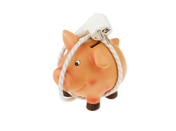 Ein Sparschwein mit Stromkabel und Stecker. Energie sparen und Kosten sparen.