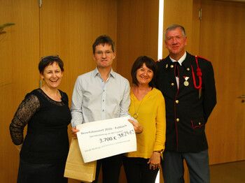Vier erwachsene Menschen stehen für ein Gruppenfoto zusammen. Bernd Kliesch hält dabei einen Check in der Hand. 