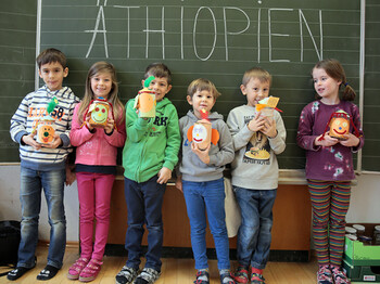 Sechs Volksschulkinder präsentieren ihre Bastelfiguren vor einer Tafel. Auf der Tafel ist mit großer Schrift Äthiopien zu lesen.