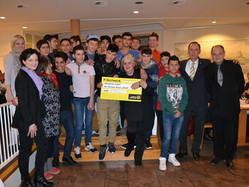 Die Jugendlichen vom Flüchtlingshaus Said versammeln sich für ein Gruppenfoto. Dabei hält eine Dame einen Spendencheck in der Hand.