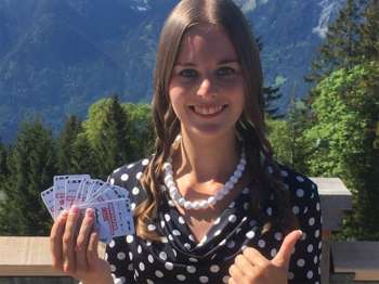 Eine Frau hält Karten in die Kamera am Muttersberg