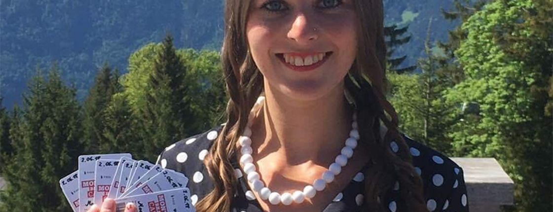 Eine Frau hält Karten in die Kamera am Muttersberg