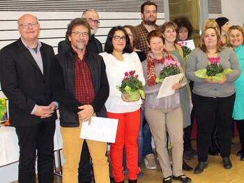 Gruppenfoto der Sozialpaten mit Peter Klinger. Sie alle sind modisch schick angezogen in ganz unterschiedlichen Farben. Manche Personen haben Blumen in den Händen. 