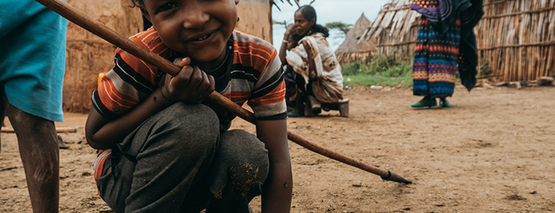kind mit stab am boden in afrika