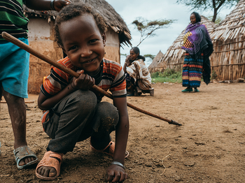 kind mit stab am boden in afrika