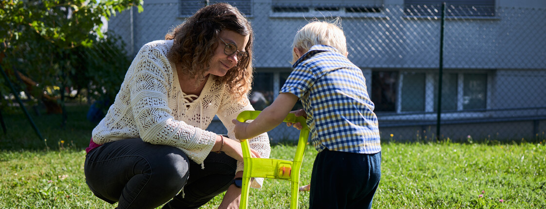 Frau spielt mit Kleinkind im Garten