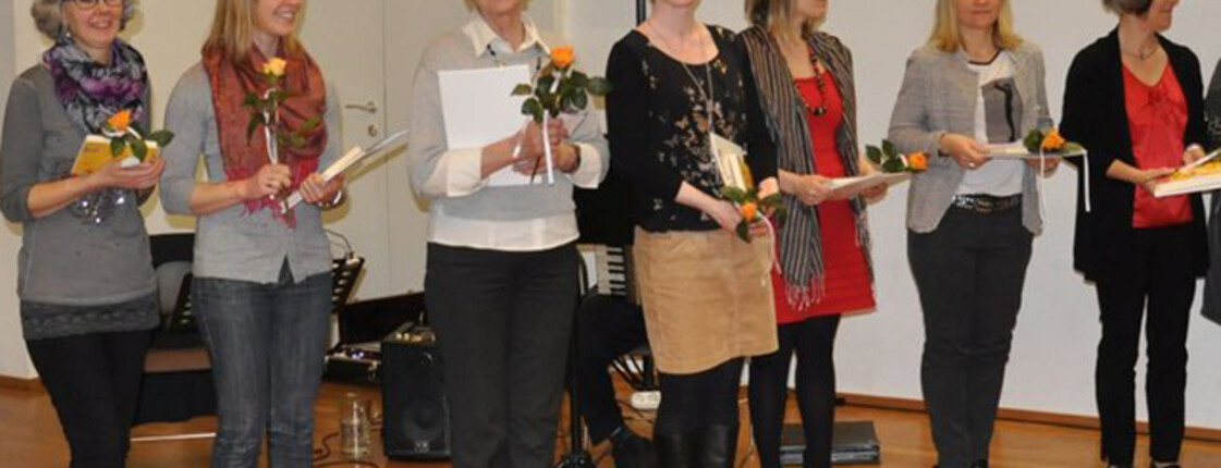 © Katholische Kirche Vorarlberg Zech Lesepaten halten eine Rose in der Hand und lachen in die Kamera.