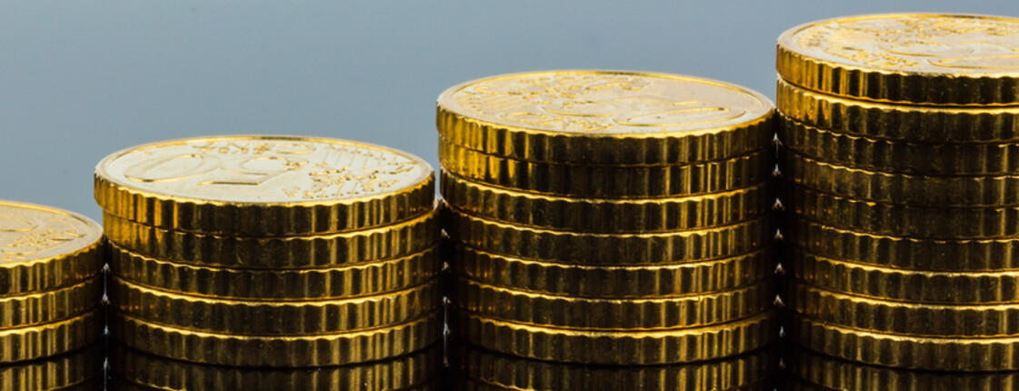 Ein Haufen von Münzen, die gestapelt sind, stehen auf einem neutralen Untergrund. 