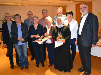 Ehrung von Freiwilligen. Ein Gruppenfoto von mehreren Menschen in einem hellen Raum.