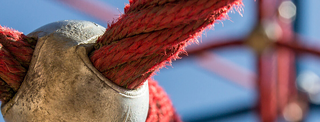 Eine Nahaufnahme von roten Seilen, die zu einem Netz verknüpft sind. 